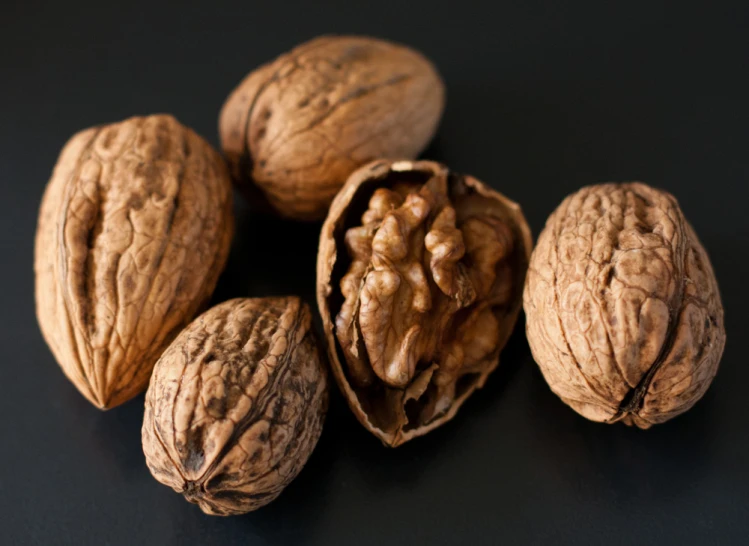 an assortment of nuts displayed on table and black background