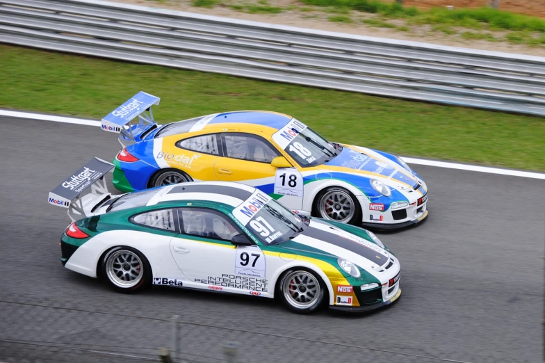 two racing cars side by side at the top of a track