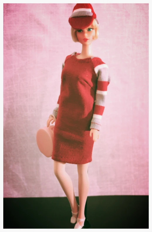 a doll dressed in red with a red and white sweater and hat
