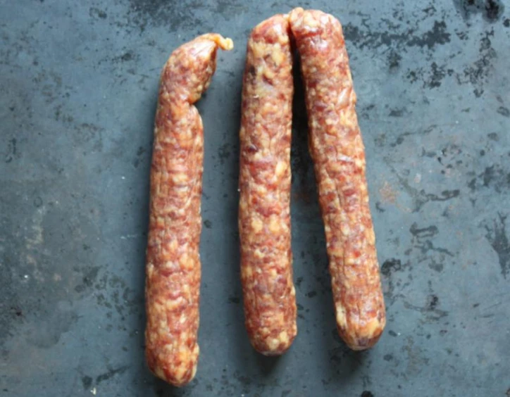 three sausages sitting on a  board together