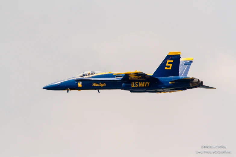 a blue angel plane flies through the sky