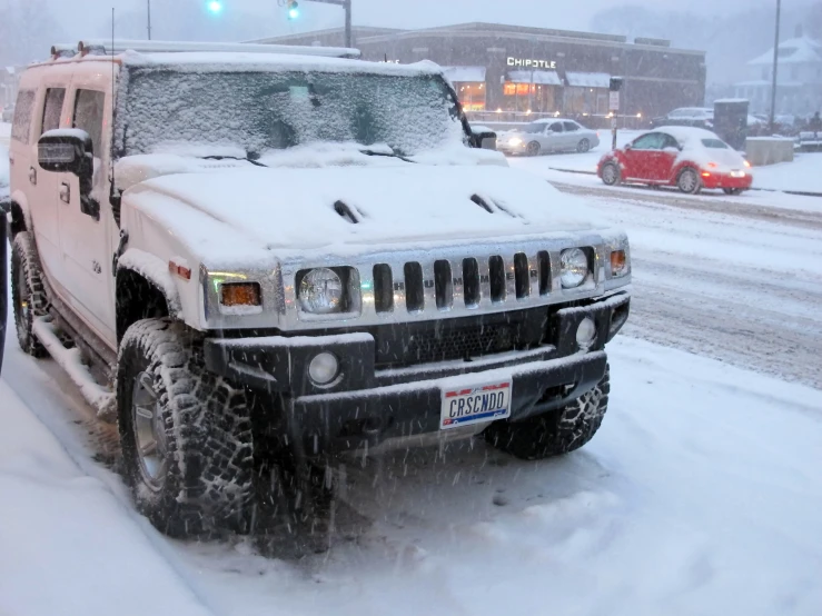 hummer truck on snow covered street with traffic light