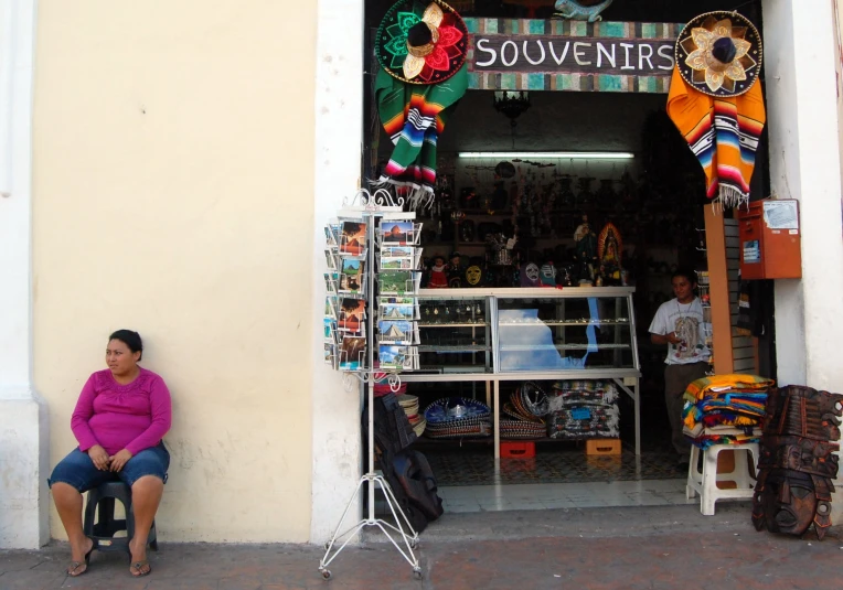 two people sitting outside of a shop window