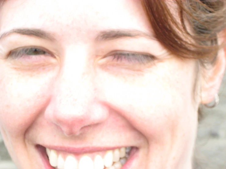 a woman with brown hair smiling at the camera