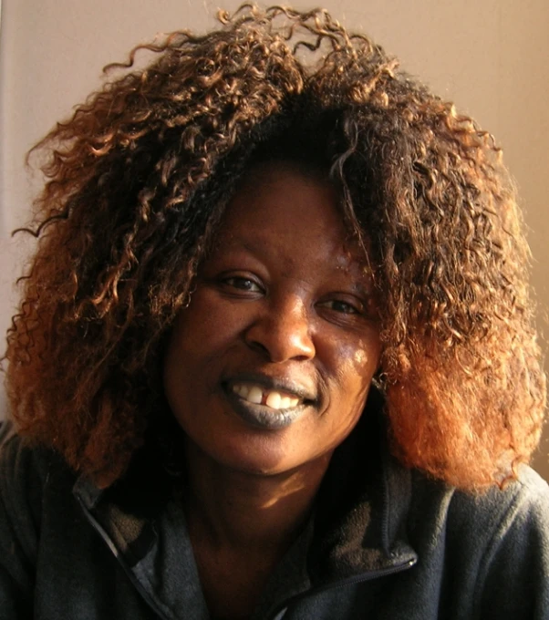 an african american woman smiling and wearing a black shirt