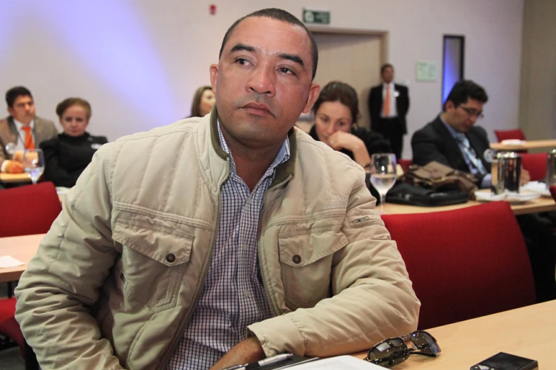 a man sitting at a table with a cell phone