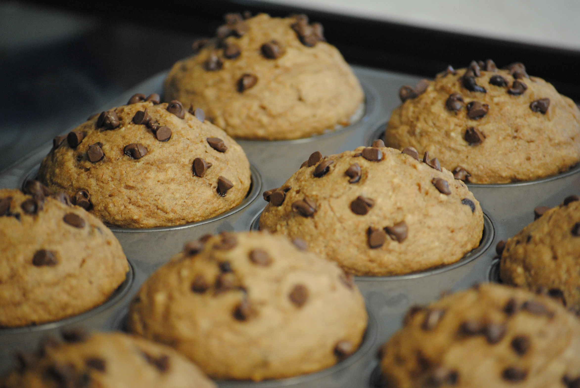 a muffin tin is filled with chocolate chip muffins