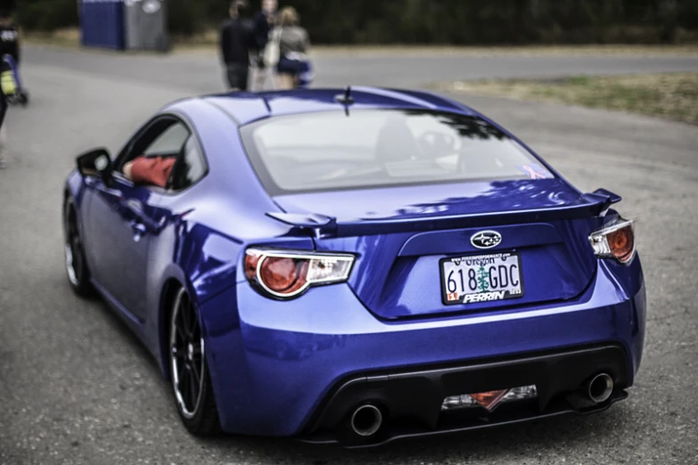 a blue car parked on the side of a road