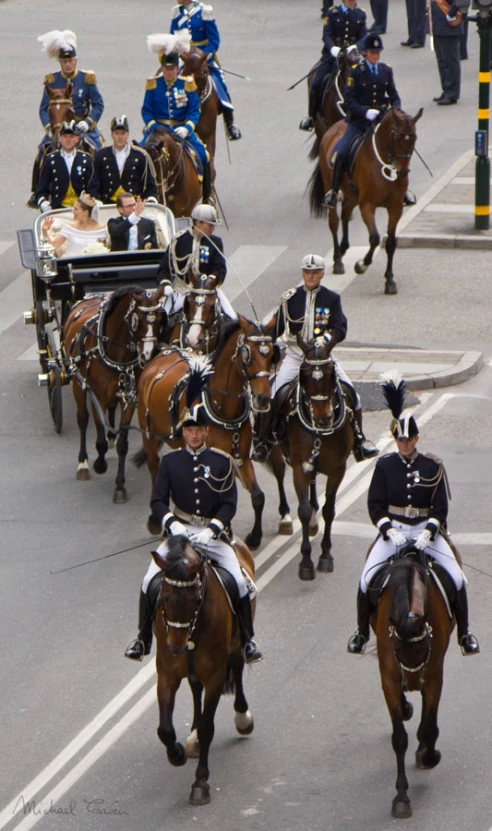 men riding horses and carriages in the street