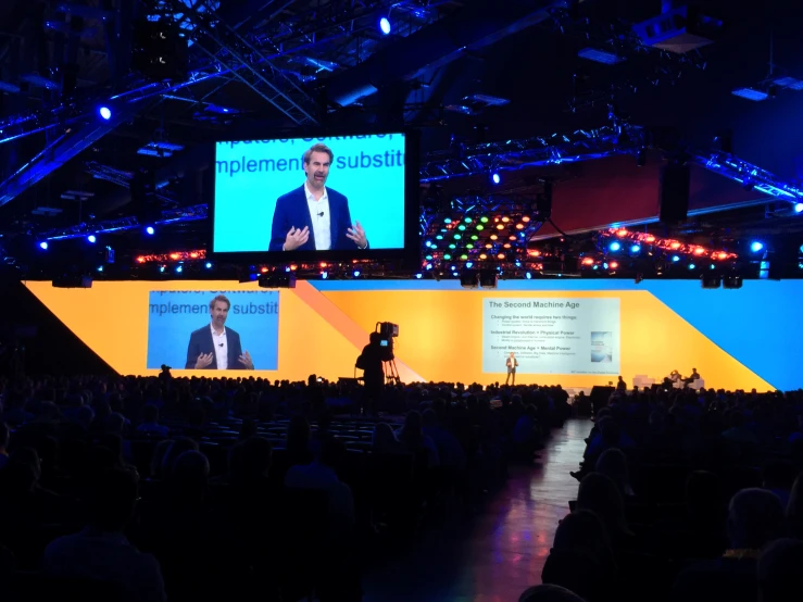 a guy presenting to a crowd on the stage