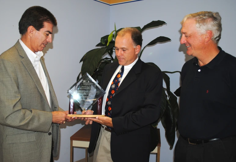 a man holds a trophy in front of other men