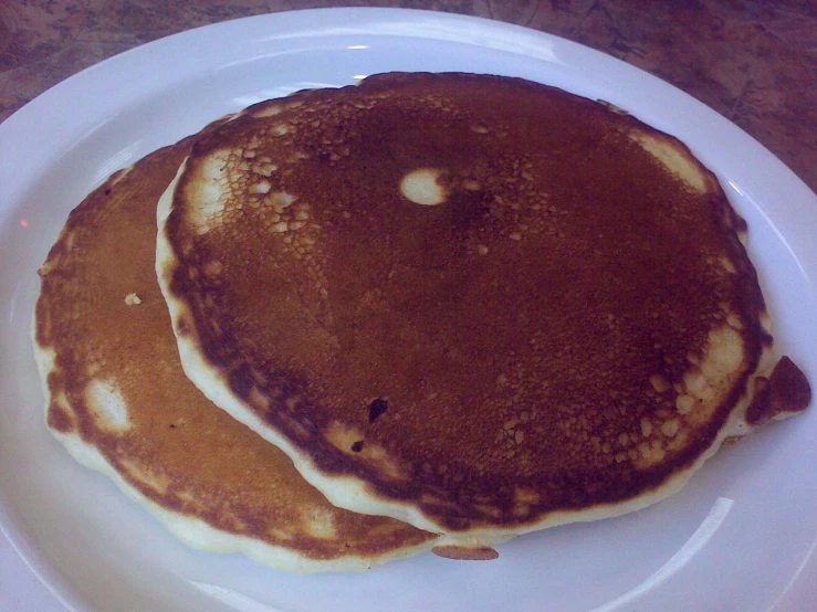 two pancakes sitting on top of a white plate