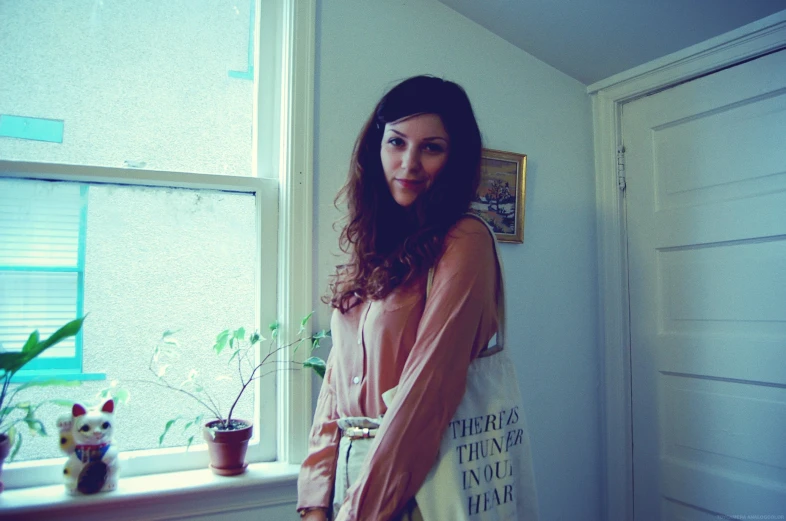 a woman is posing by the window in her home