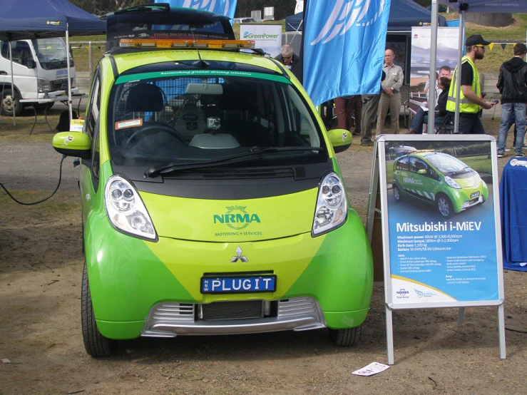 a small lime colored vehicle parked on top of dirt