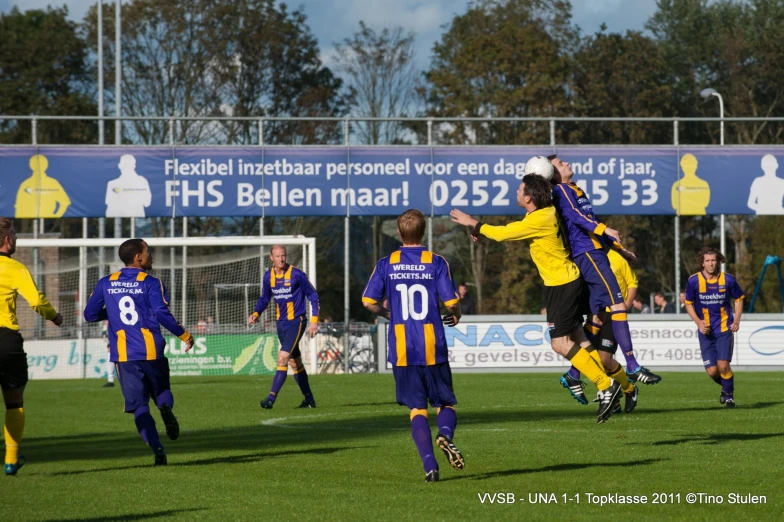 men are playing soccer and jumping in the air