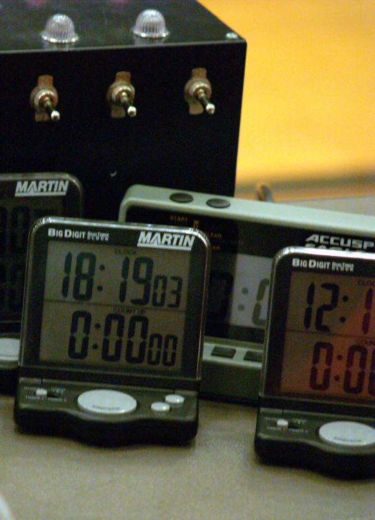 four electronic clocks sitting on top of a table