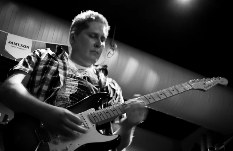 a man playing guitar inside a recording studio