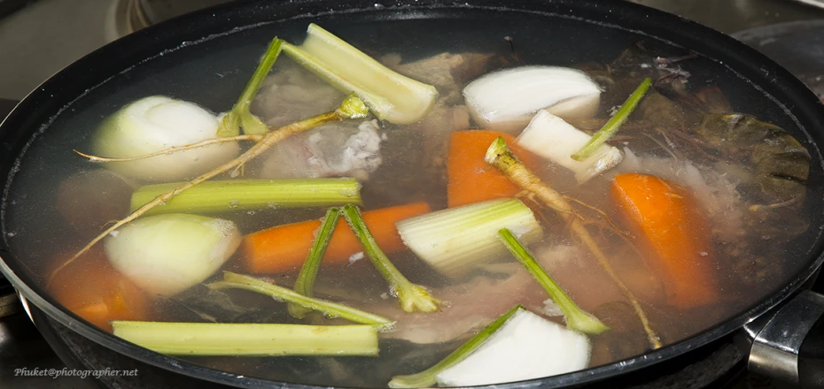 a set filled with meat and vegetables cooking on top of a stove