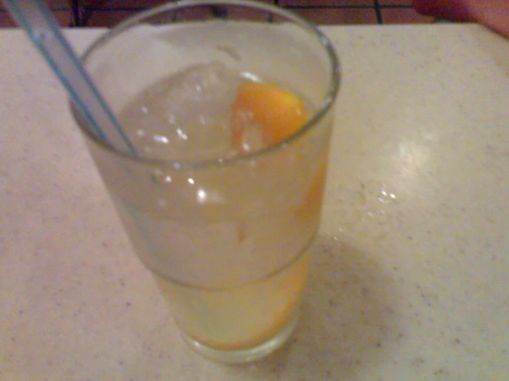 a glass with ice and an orange slice in it