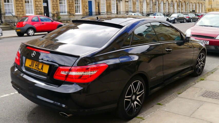 there is a small black mercedes parked in the street