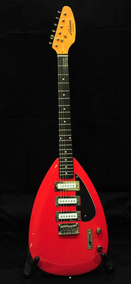 a red electric guitar is against a black background