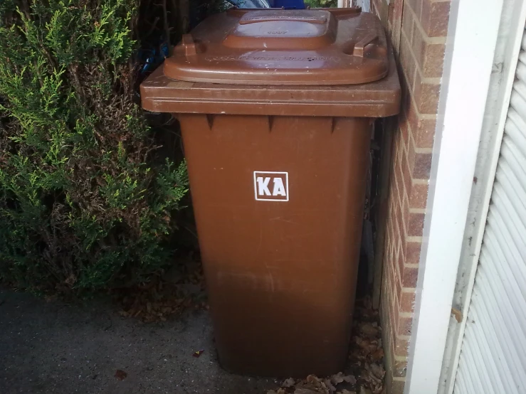 a plastic trash can next to an alleyway