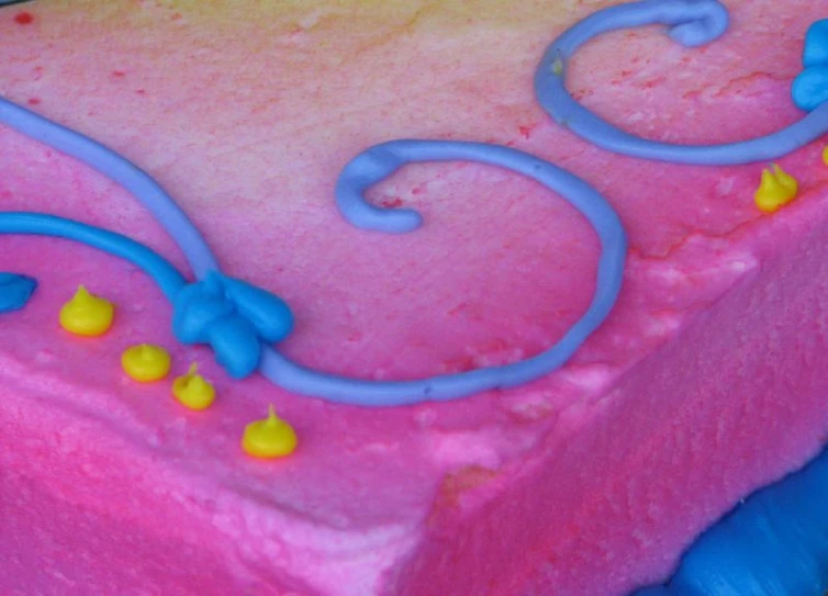a square, colorful cake with swirls and stars on top