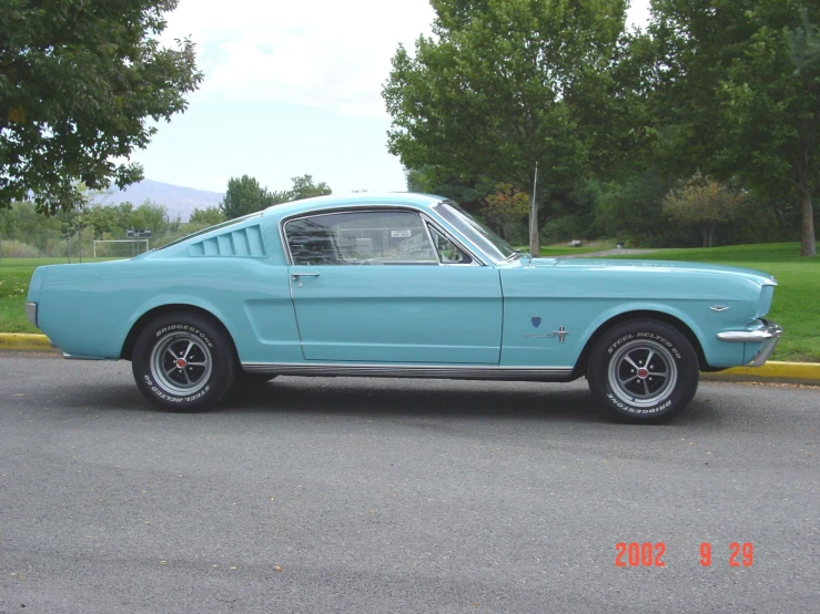 an old mustang muscle car parked in a parking lot