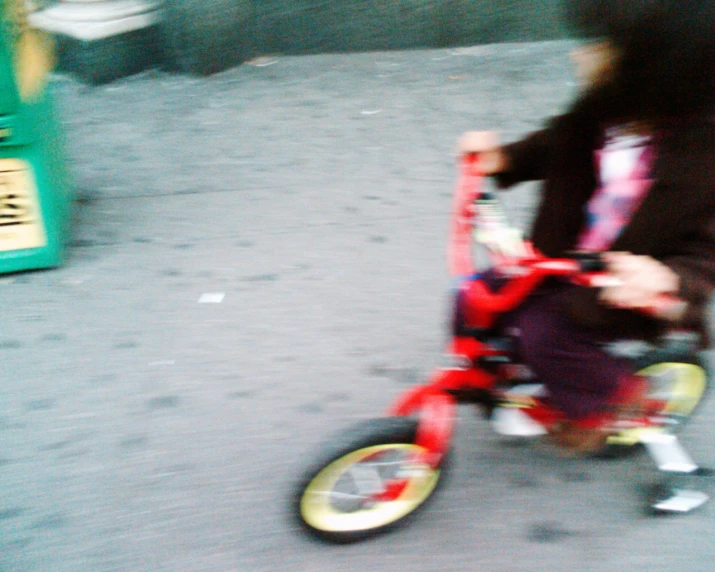 a little girl riding her toy bike down the street