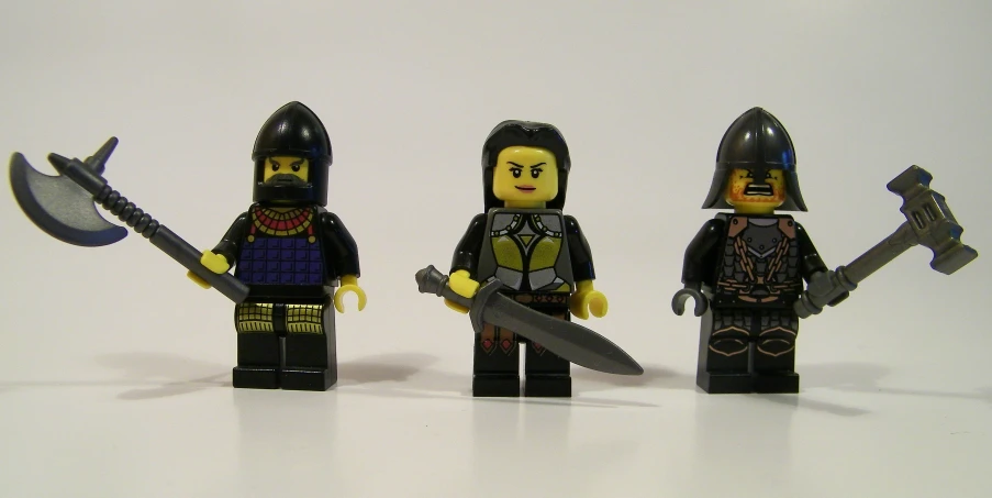 three legos, including a man in a knight suit, two in medieval dress, and one with a sword