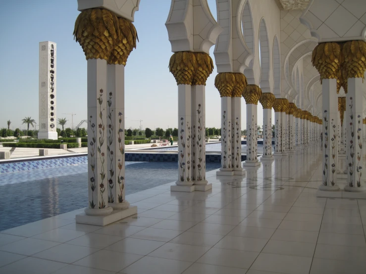 a long hallway with a pool and columns