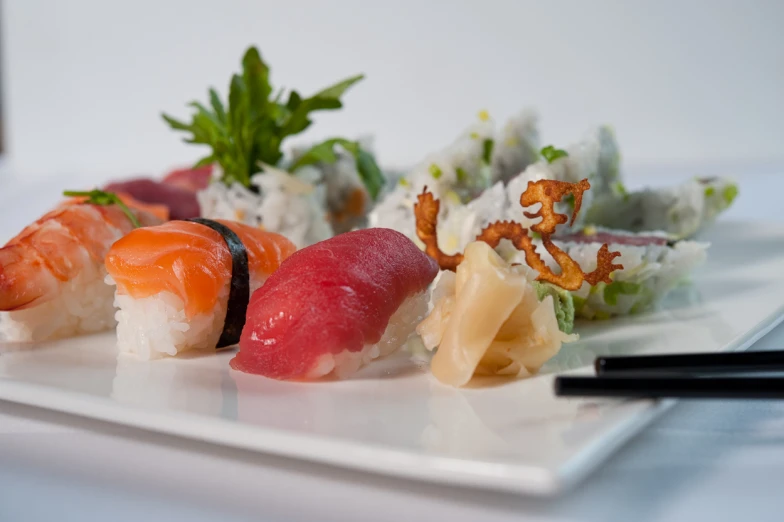 a plate with several pieces of sushi and sauce