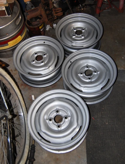 there are five flat chrome wheels next to a bike tire