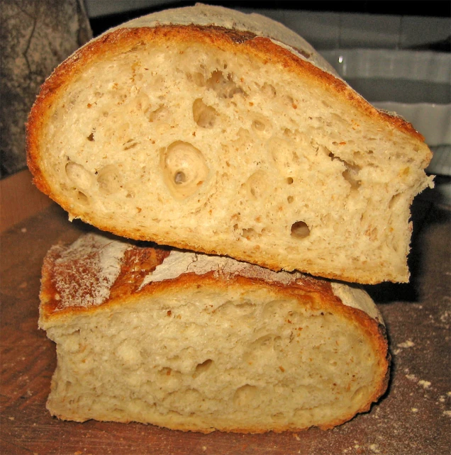 two pieces of bread sitting on top of a wooden  board