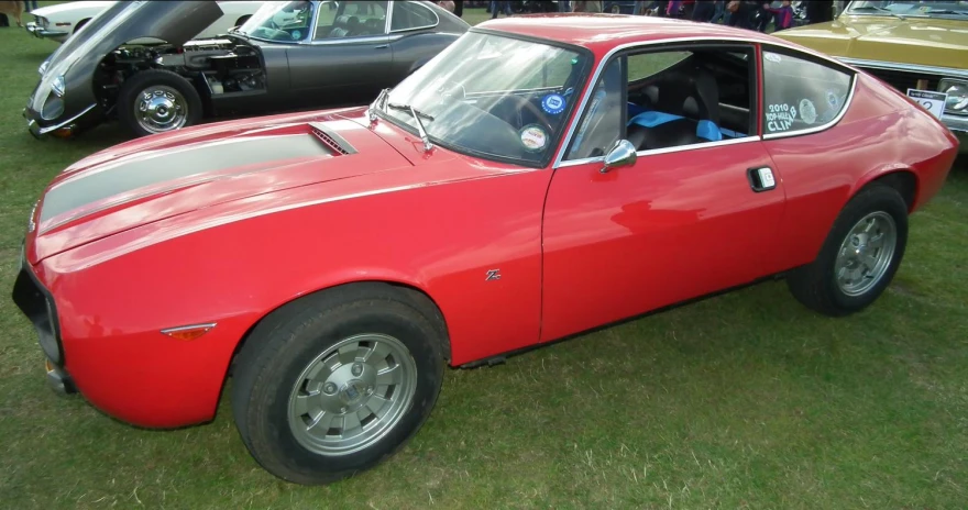 a bright red car is sitting in the grass