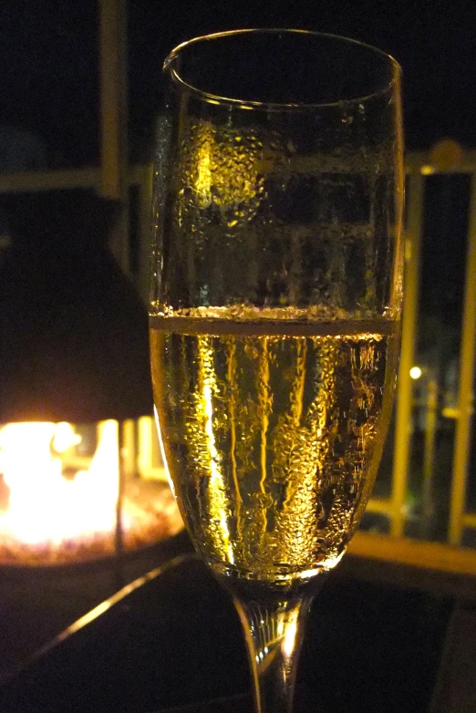 the champagne is on a table in front of a lit candle