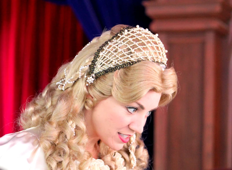 a lady with a pearl head piece in her hair