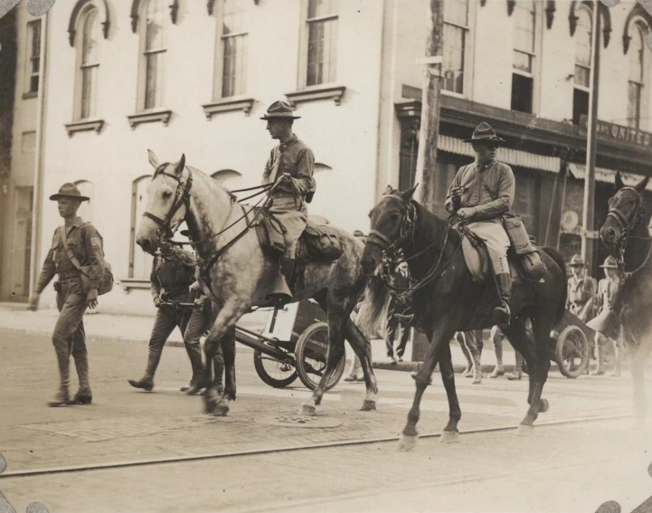 men in uniform riding horses in a city street