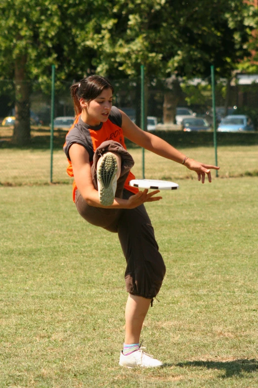 woman is stretching out and throwing a frisbee