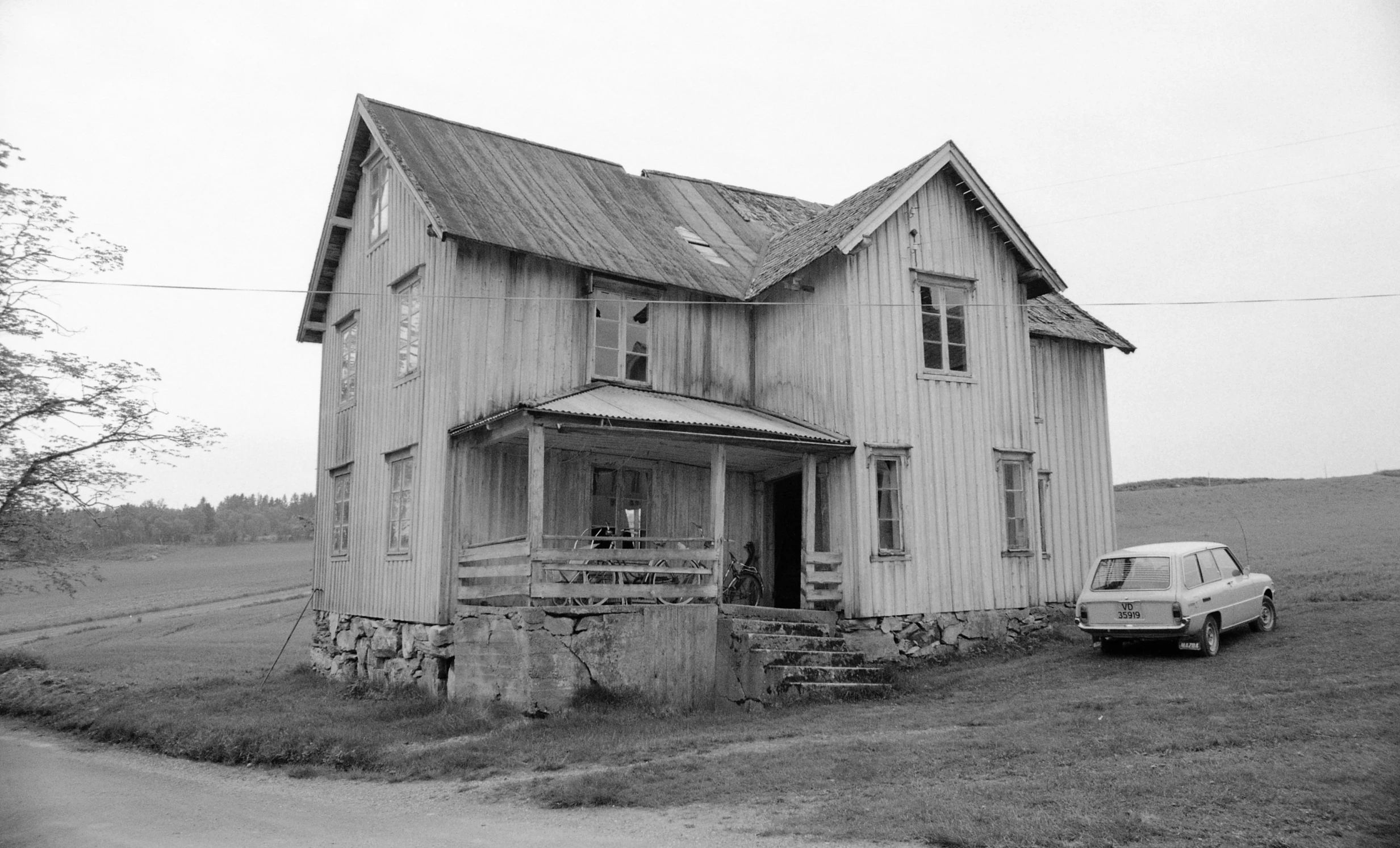 a car parked on the side of a road next to a house