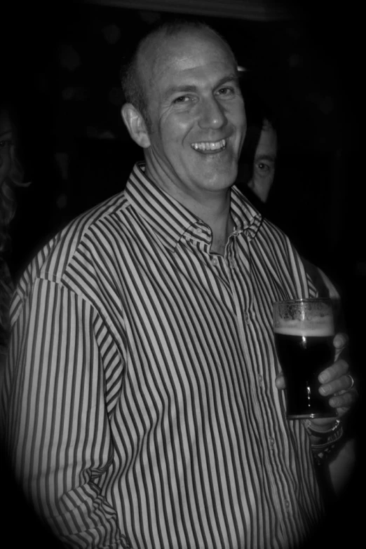 a man in a striped shirt is holding a drink