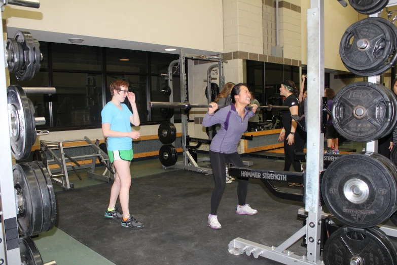 two woman are doing different tasks in the gym