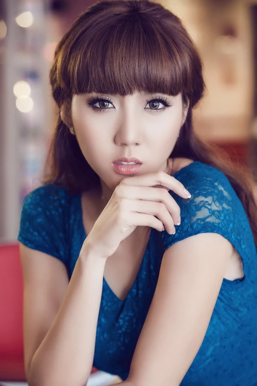 woman with dark hair wearing blue dress posing for picture