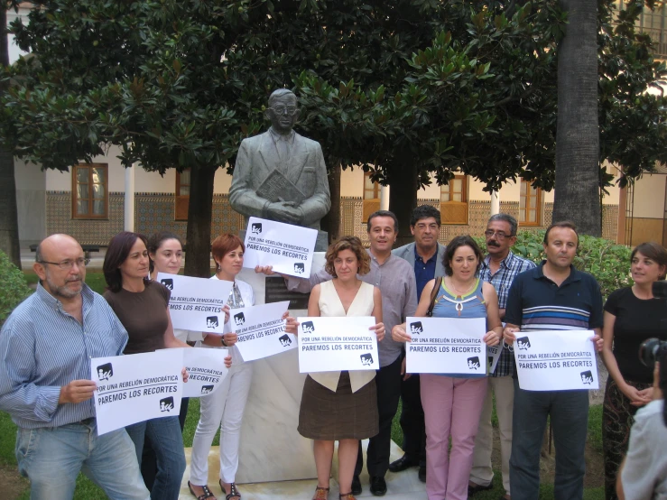 people holding signs and standing next to trees