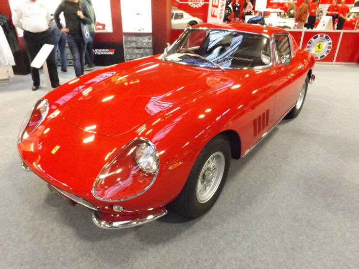 there is an old red sports car at the show