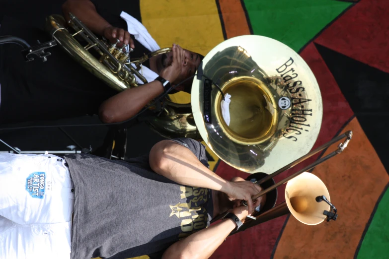 two people that are playing instruments with a big colorful building behind them