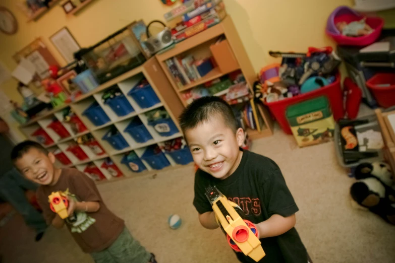 two s in a play room holding toys