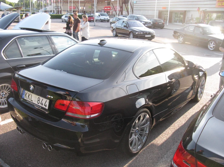 black bmw is parked near an outside sidewalk