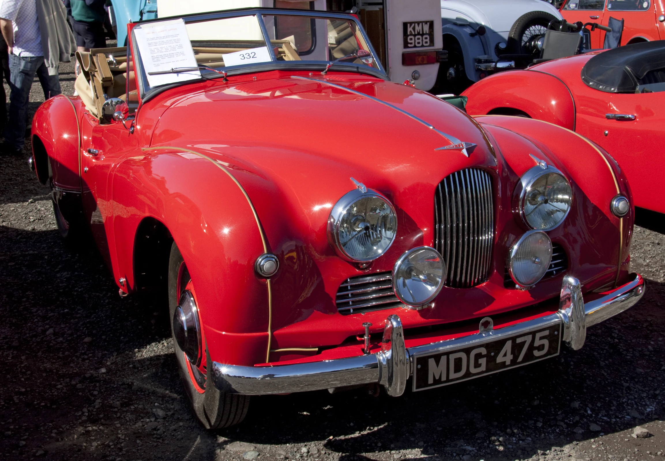 two red vintage cars that are on display