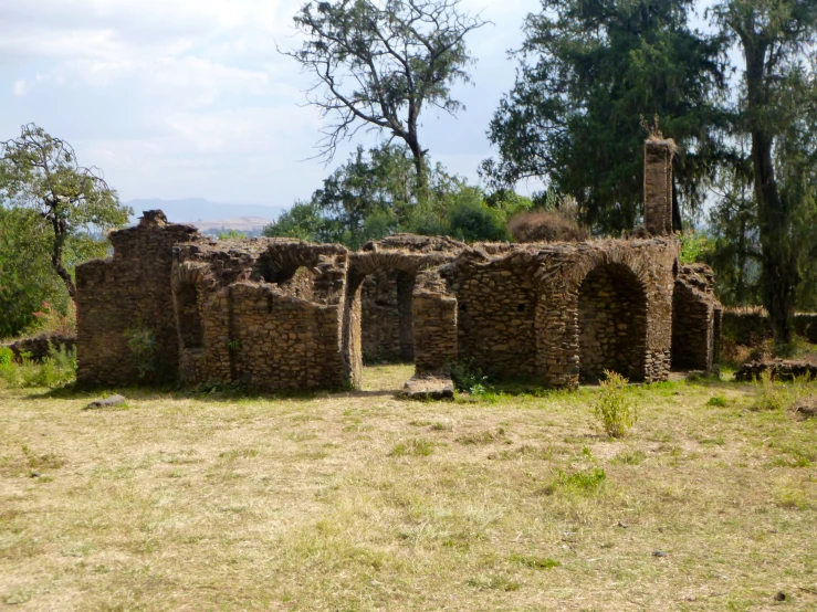 an old stone building sitting in the grass